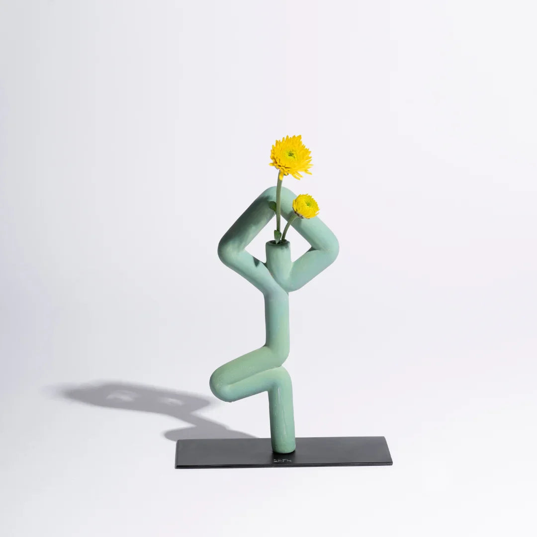 Sculptural vase shaped like a Vrikhasana yoga pose on a white background